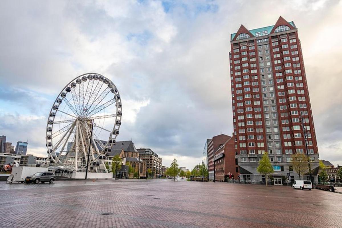 una ruota panoramica in un parcheggio accanto a un edificio alto
