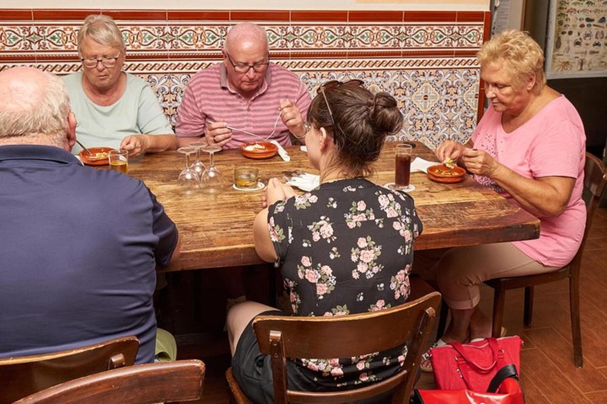 un grupo de personas sentadas alrededor de una mesa de madera