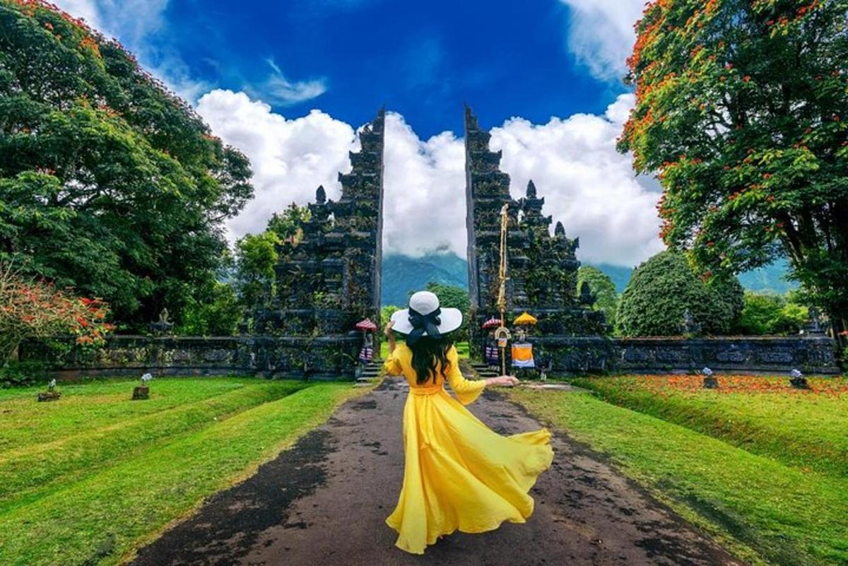 una donna in un vestito giallo che cammina lungo una strada sterrata