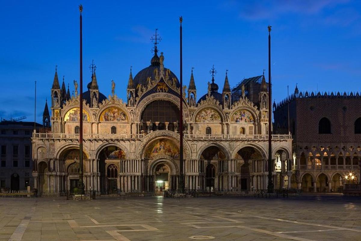Un gran edificio de piedra con una catedral por la noche.