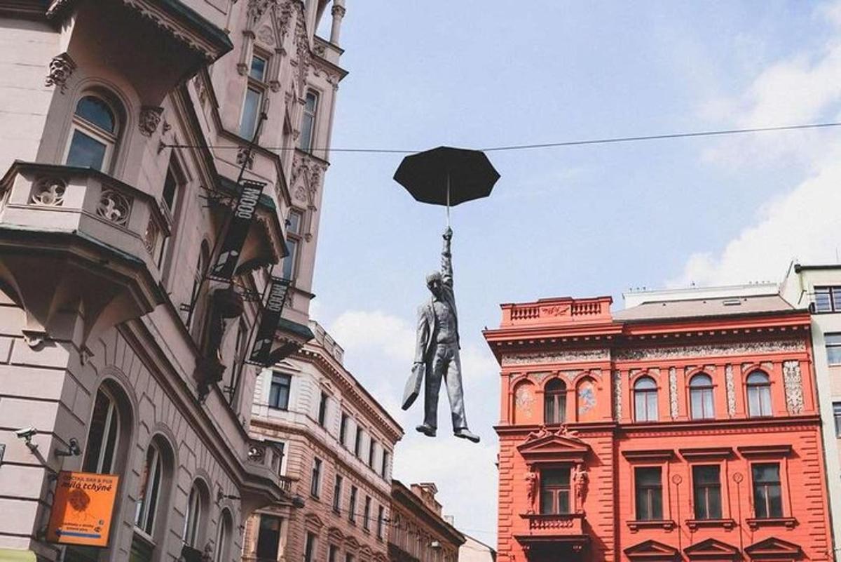 kip moškega, ki visi z dežnikom z zgradbe