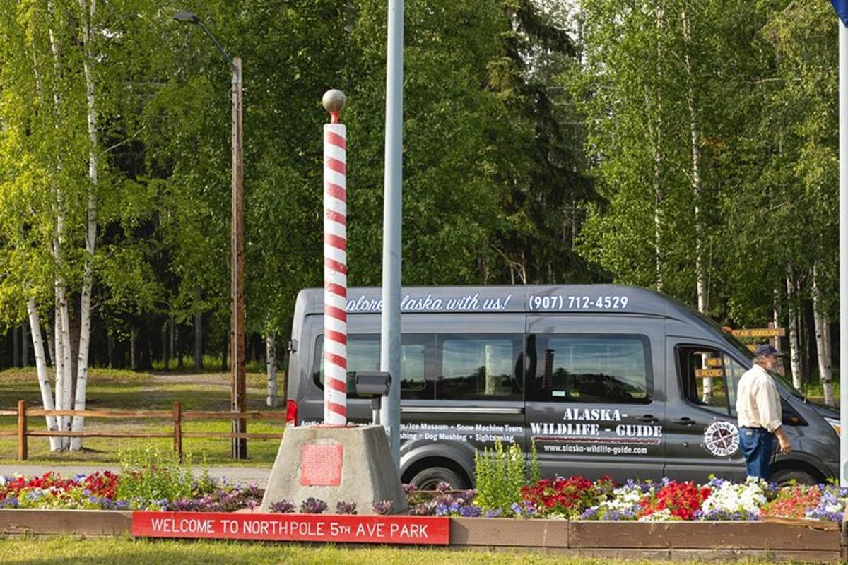 a van parked in a park with a red and white pole