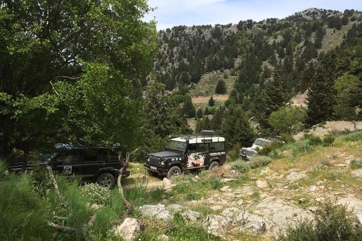 two trucks parked on a dirt road in a mountain