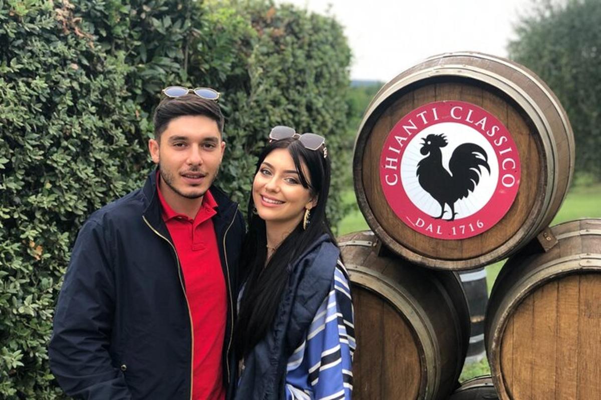 un uomo e una donna in piedi accanto a botti di vino