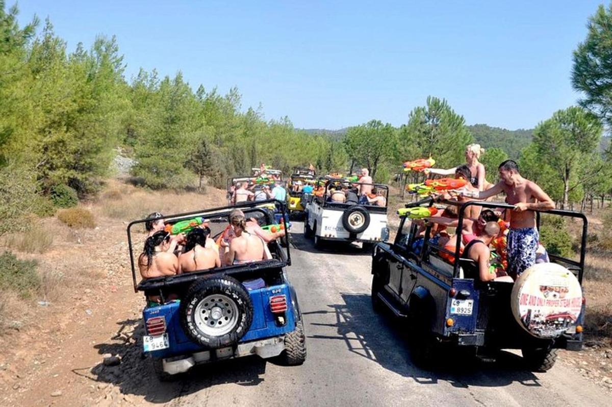 eine Gruppe von Menschen, die in Jeeps auf einer unbefestigten Straße fahren