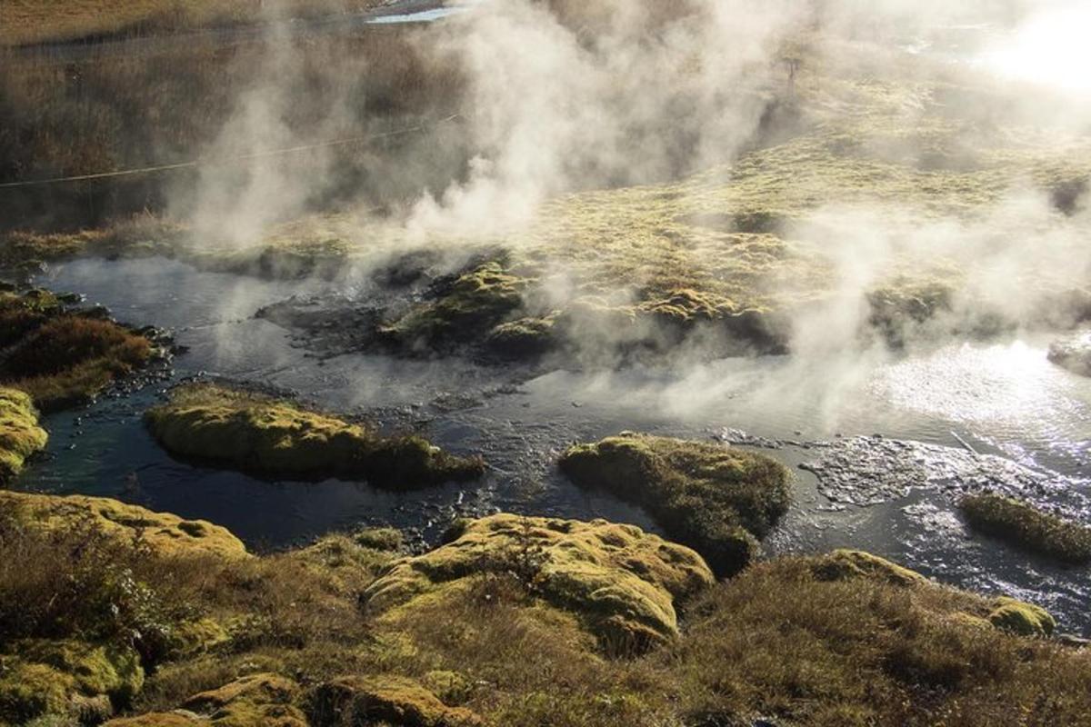 a geyser with steam coming out of it and rocks