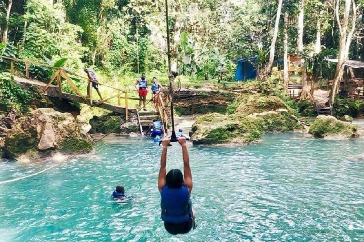 a person standing in a river with their hand in the air