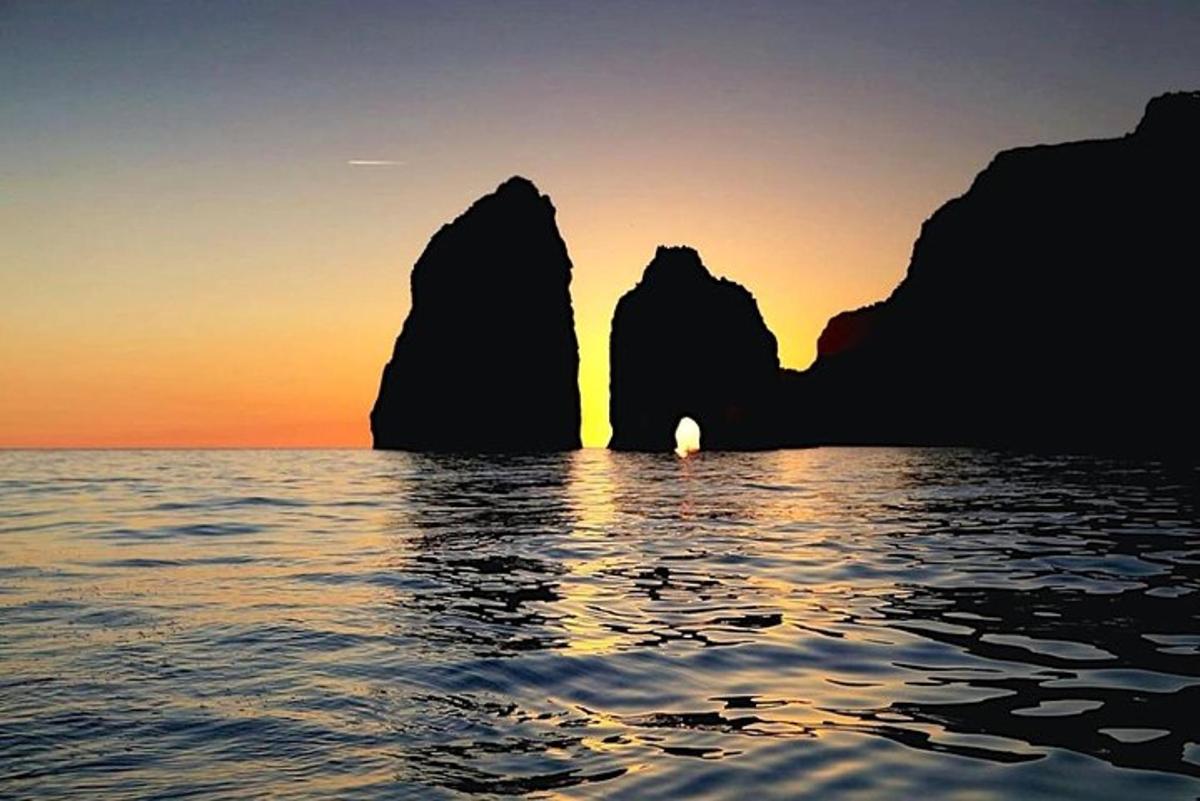 Západ slunce nad oceánem s kameny ve vodě