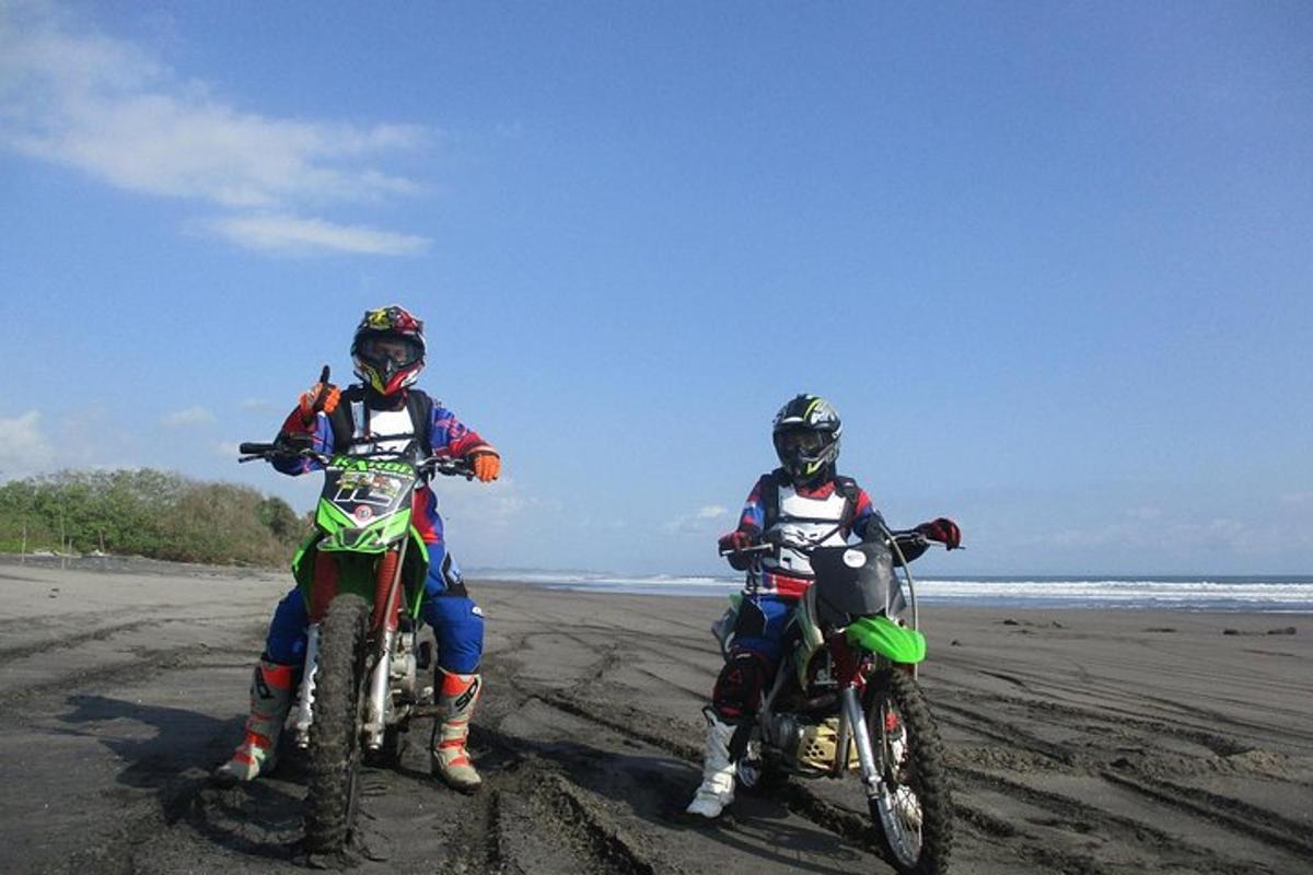 dues persones en motos de cross a la platja