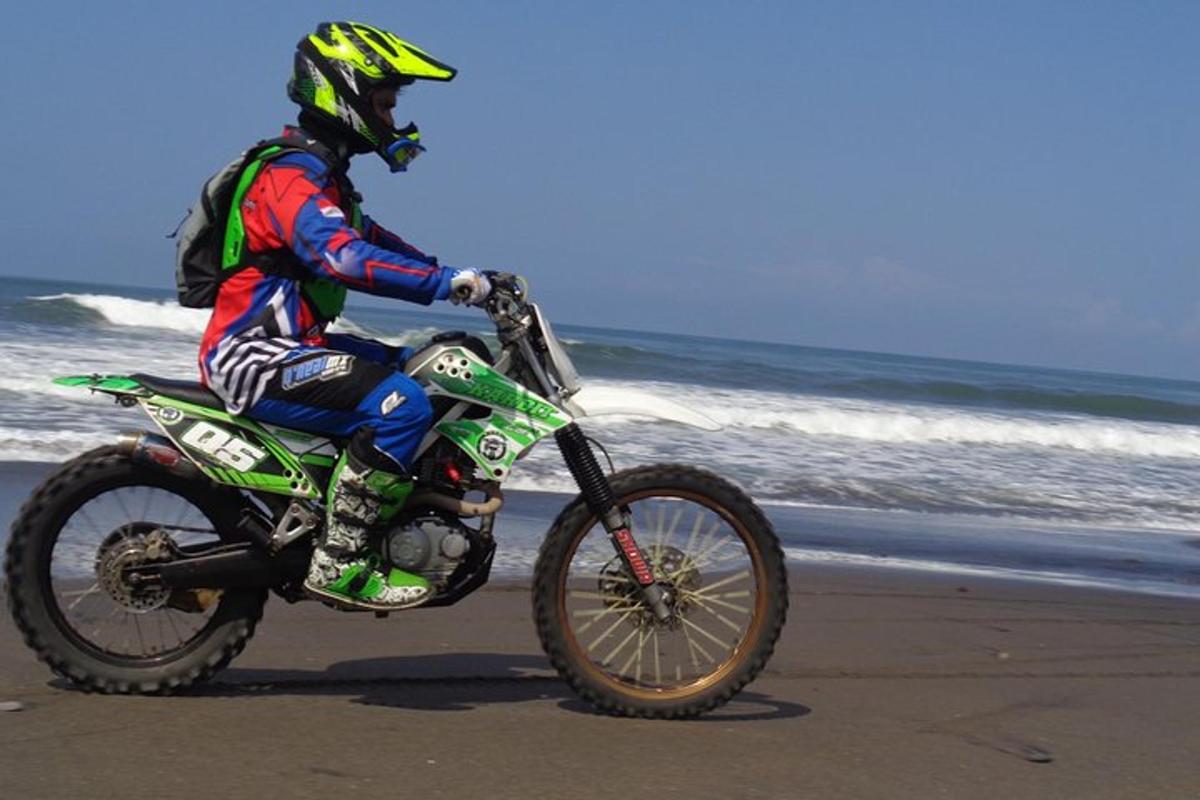 una persona anant amb una moto de cross a la platja