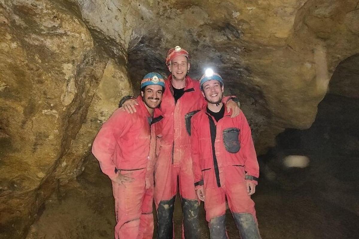 a group of three people standing in a cave
