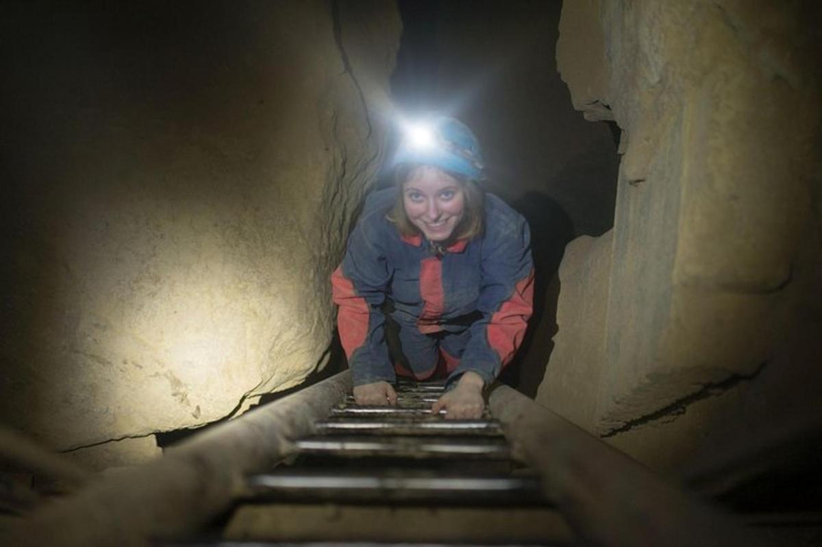 a woman walking down a stairs in a tunnel