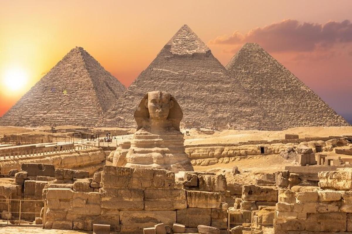 une statue de lion se dresse devant les pyramides