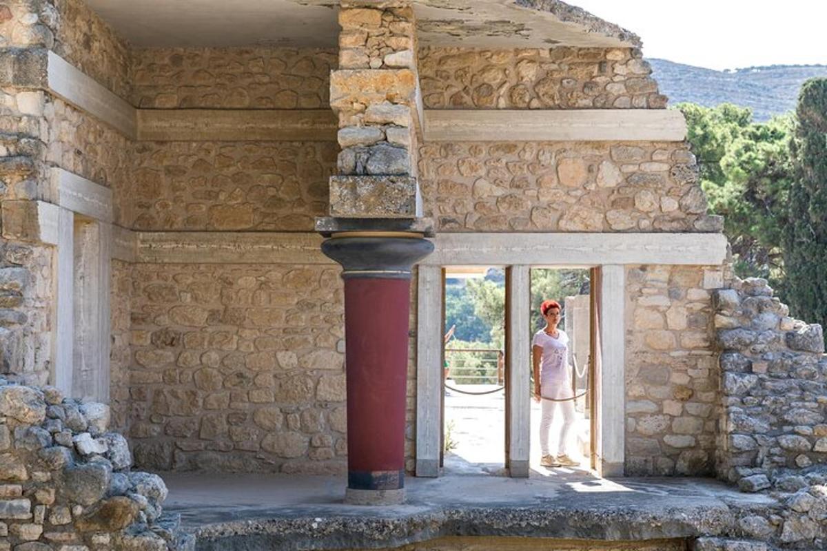 μια γυναίκα που στέκεται στην πόρτα ενός πέτρινου κτιρίου
