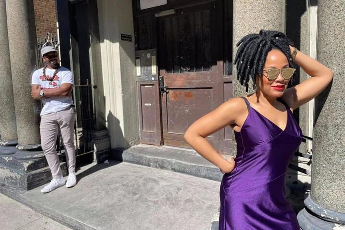 a woman in a purple dress standing in front of a building