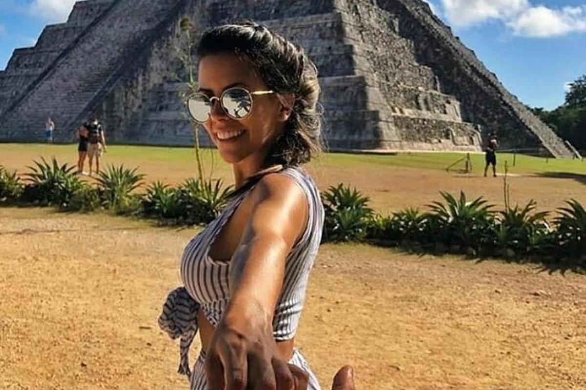 a woman in sunglasses standing in front of a pyramid