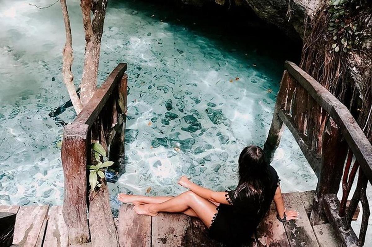 una mujer sentada en un puente mirando el agua