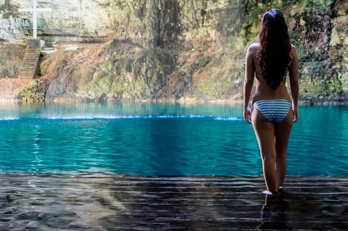 a woman in a bikini walking into a body of water