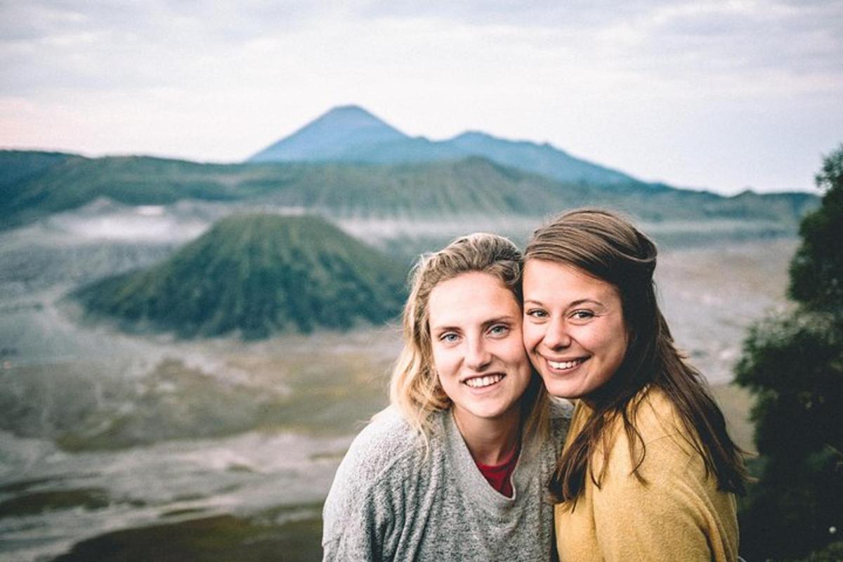 two women posing for a picture in the mountains