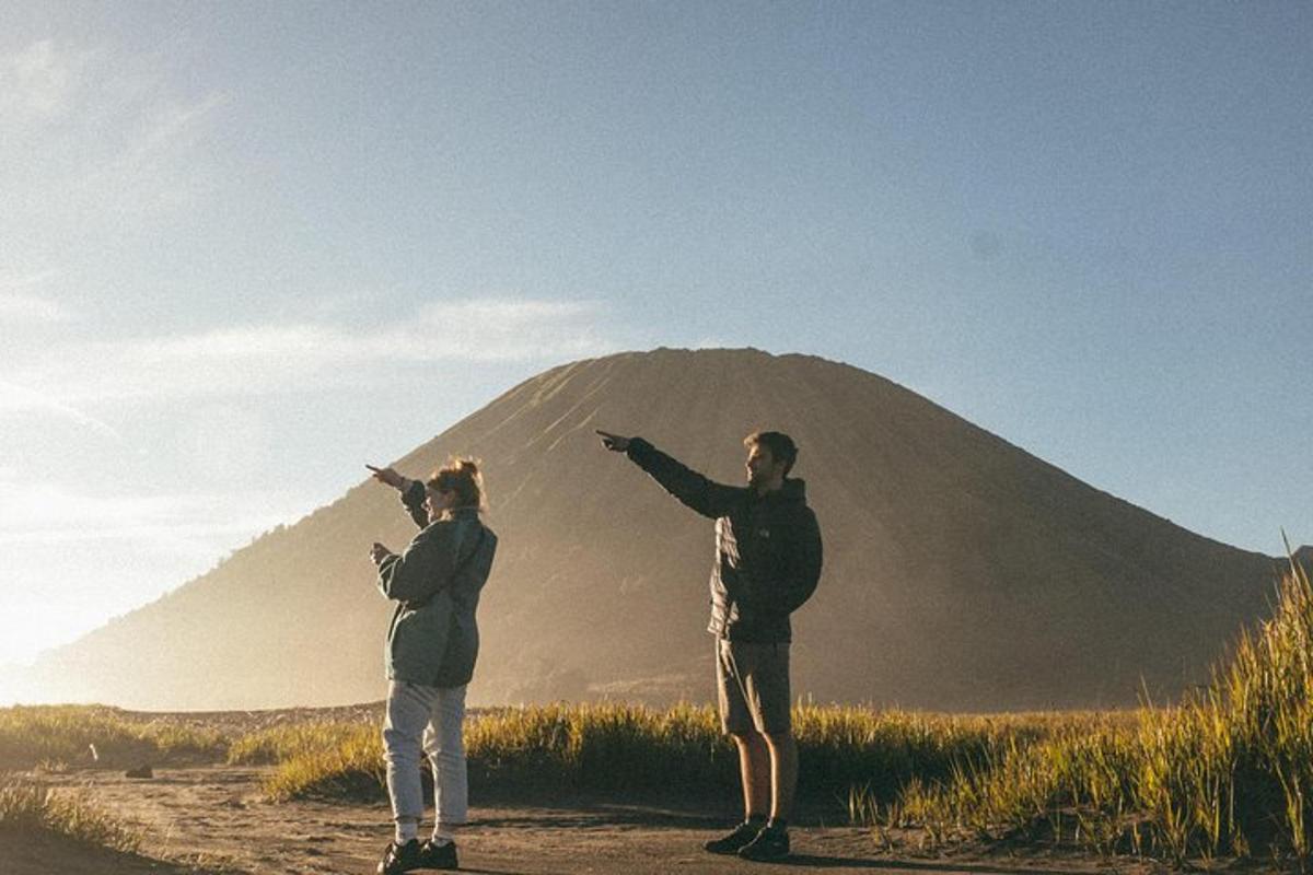 a man and woman standing in front of a mountain