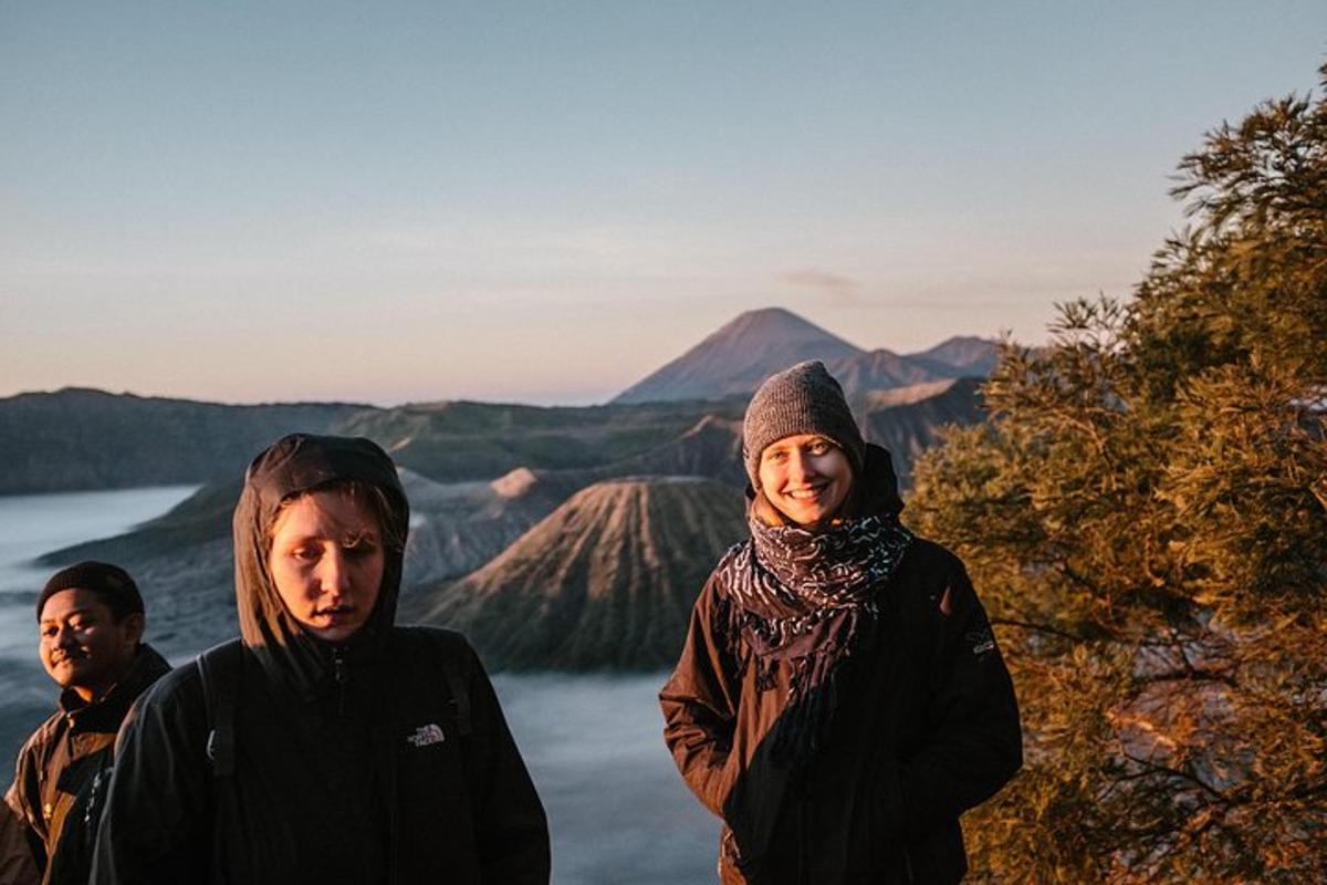 a group of people standing in front of a mountain