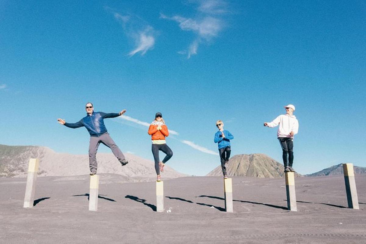 a group of people jumping on posts in the desert