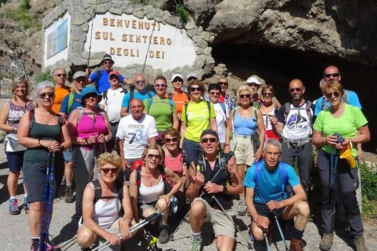 um grupo de pessoas posando para uma foto em frente a uma caverna