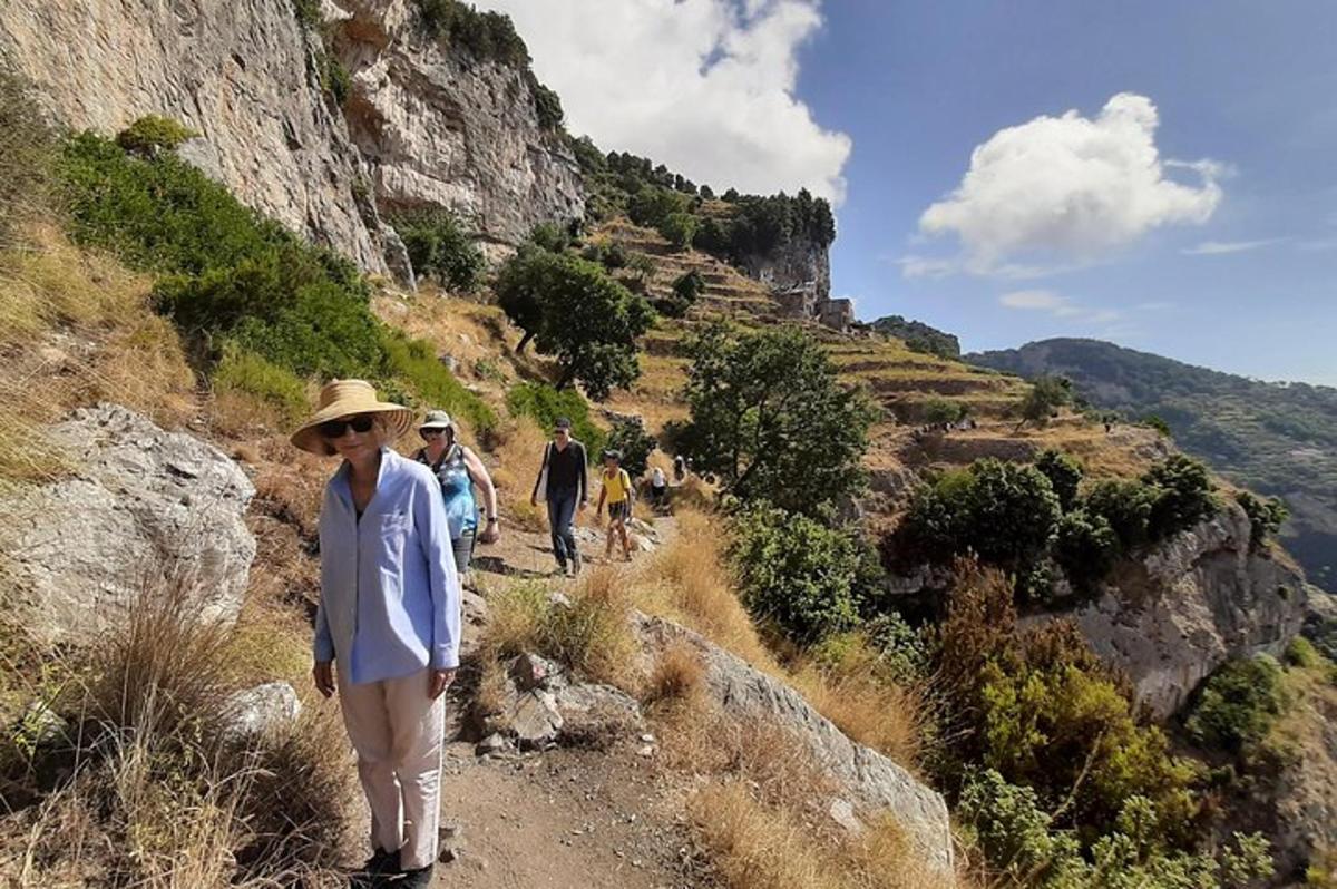 uma mulher parada em uma trilha de terra em uma montanha