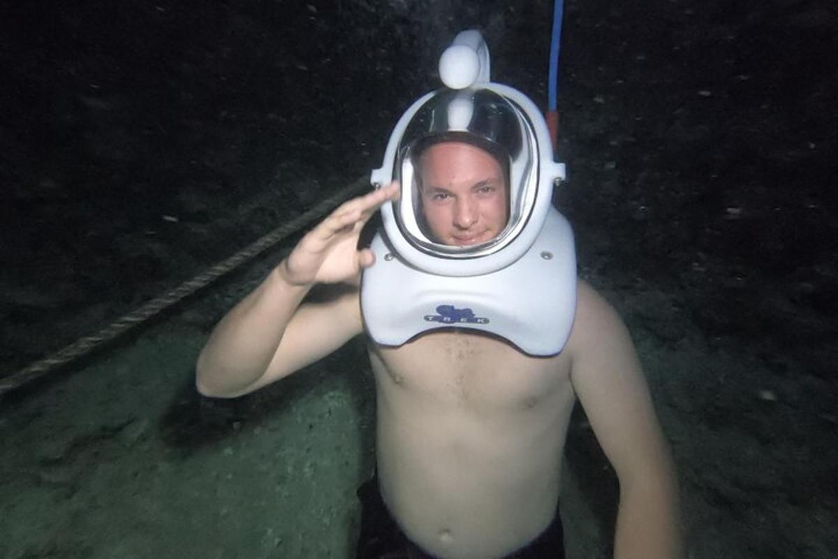 muž ve vodě s potápěčskou helmou