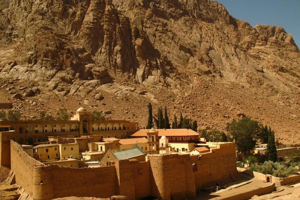 uma vila no deserto com uma montanha ao fundo