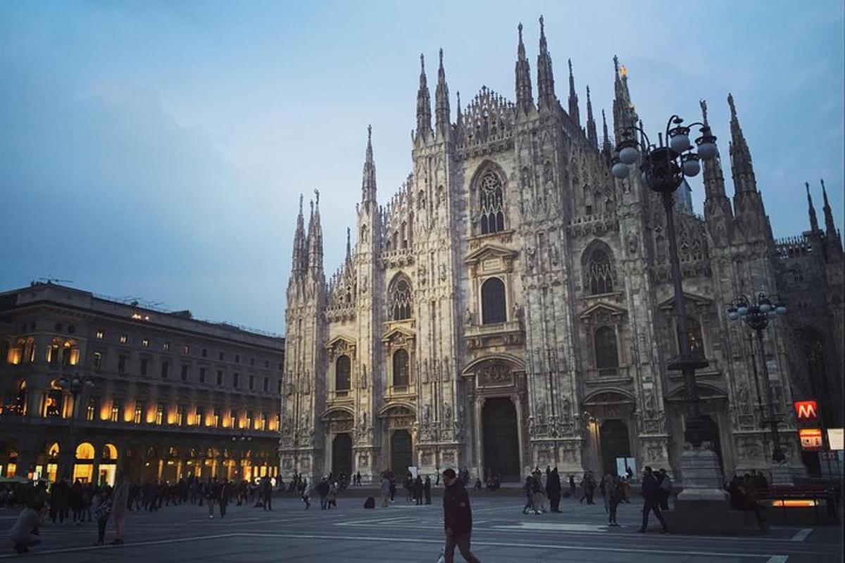 una grande cattedrale con persone in piedi davanti ad essa