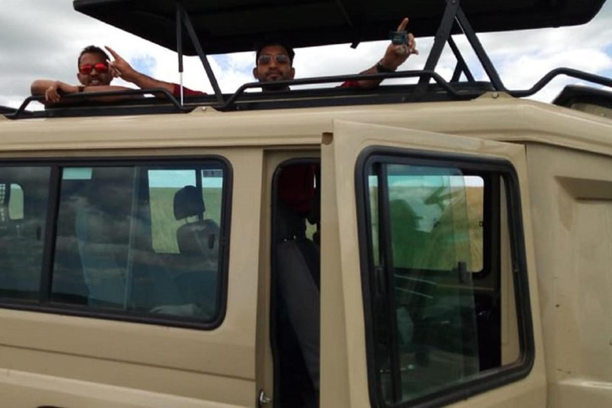 two people sitting on the roof of a vehicle