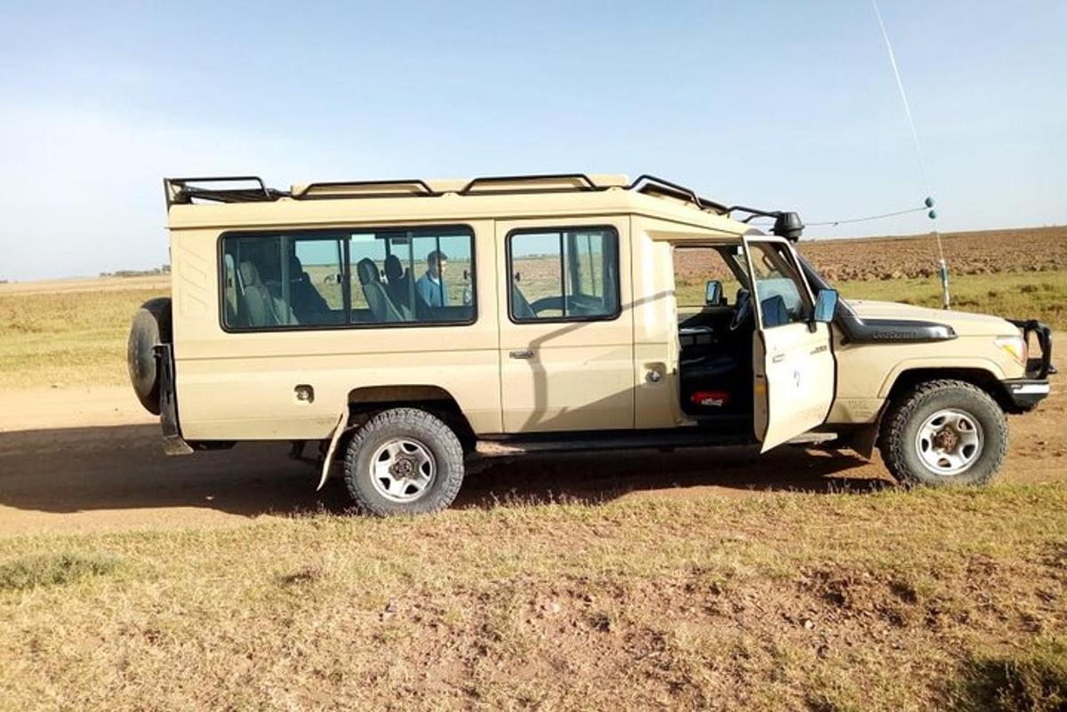 a tan jeep parked on a dirt road