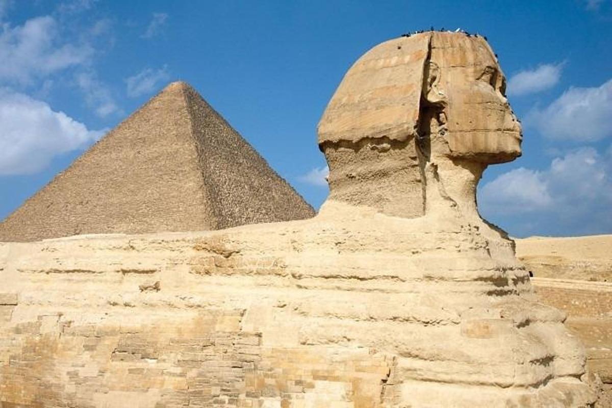 a statue in front of the sphinx and pyramid