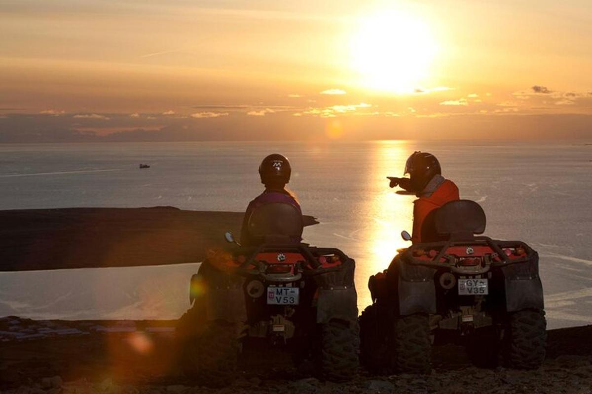 dua orang menaiki atv di hadapan matahari terbenam