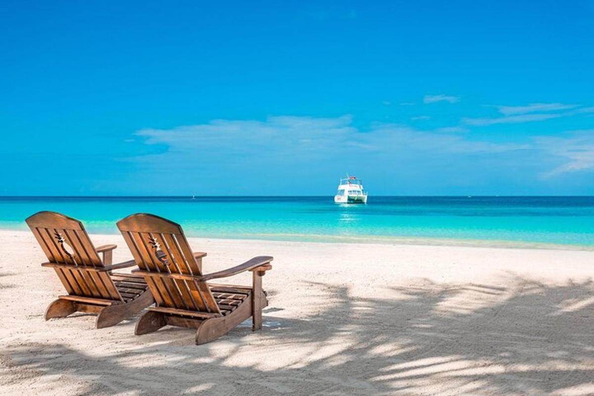 due sedie su una spiaggia con una barca in acqua