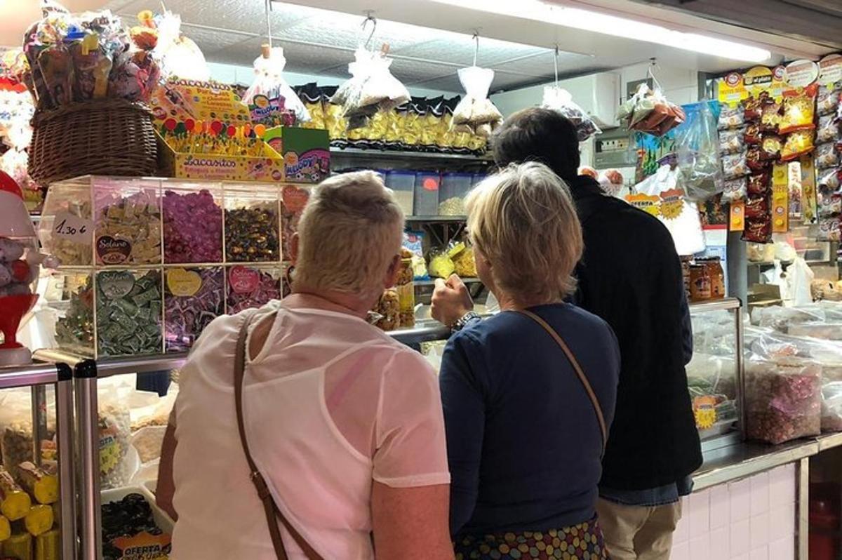 Un grupo de personas de pie en una tienda de comestibles