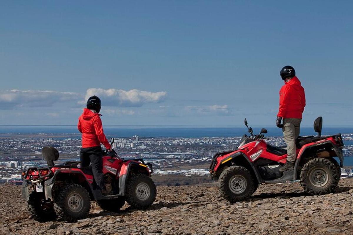 Kaks inimest istuvad ATV-del mäe otsas
