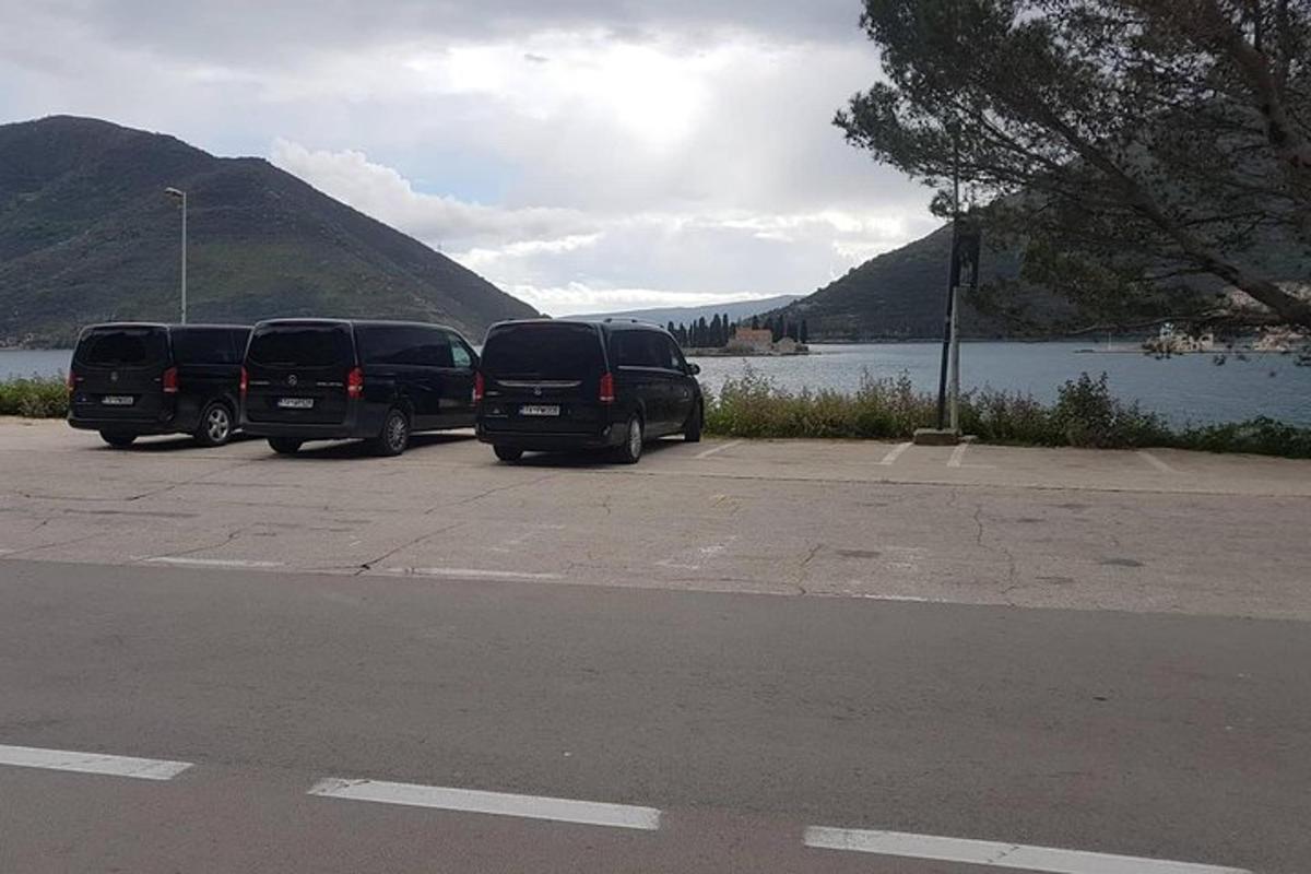 dos cotxes aparcats en un aparcament al costat d'un llac