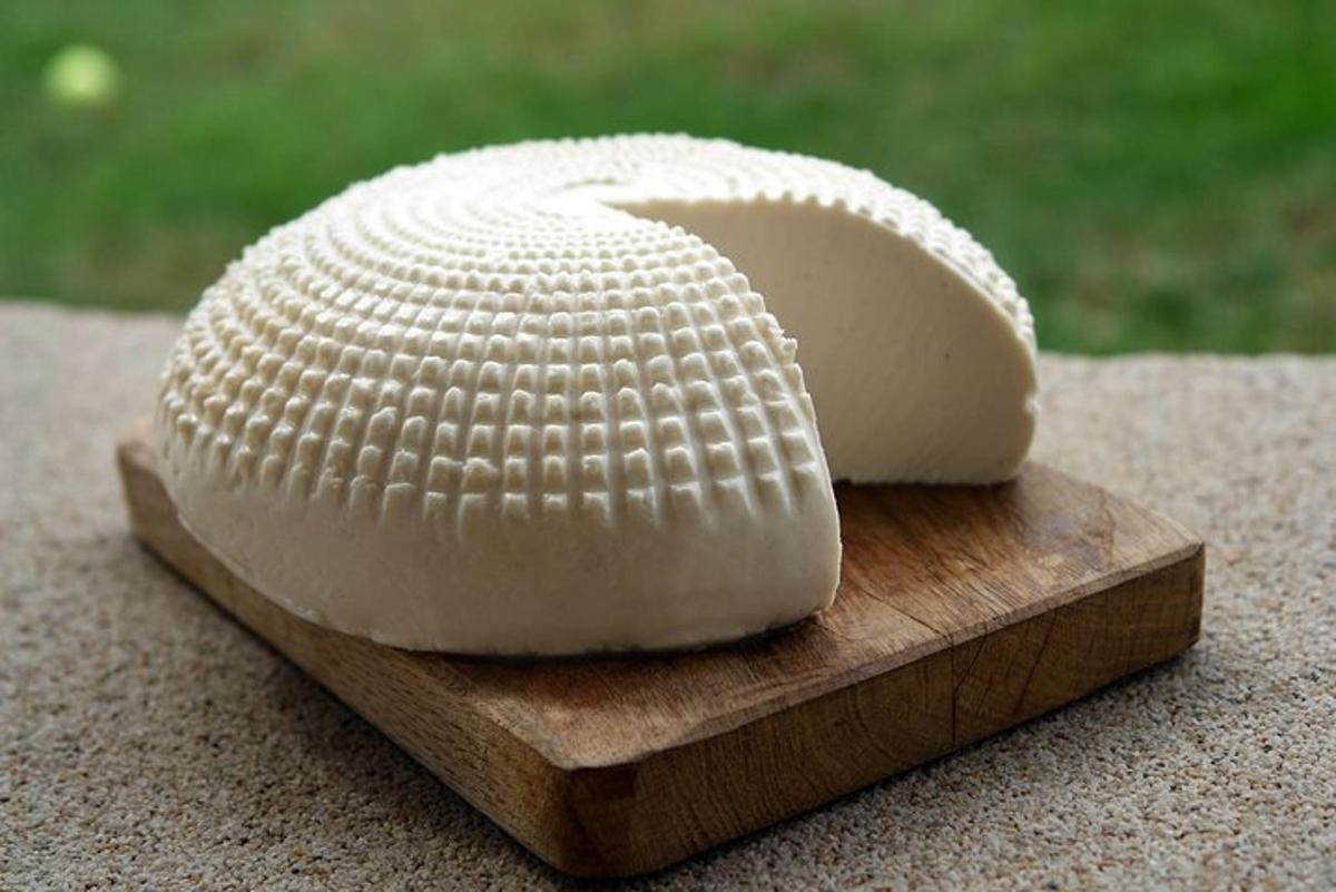 a piece of cheese on a wooden cutting board