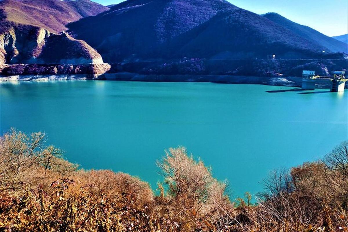 un lac mare și albastru cu munți în fundal