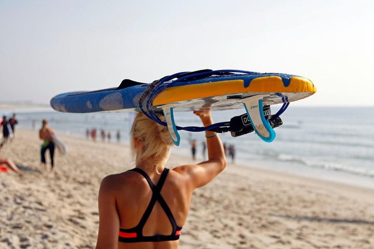 a woman in a bikini holding a surfboard on the beach