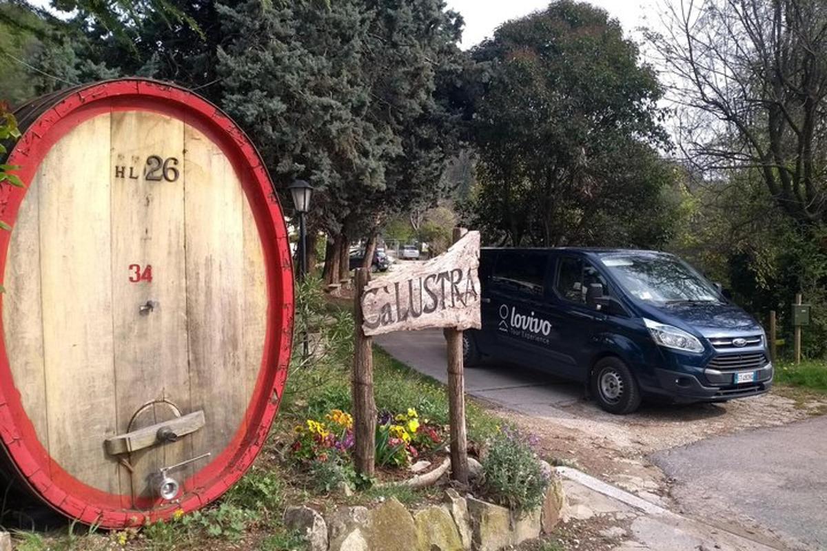 Una camioneta estacionada junto a un barril de madera y un cartel