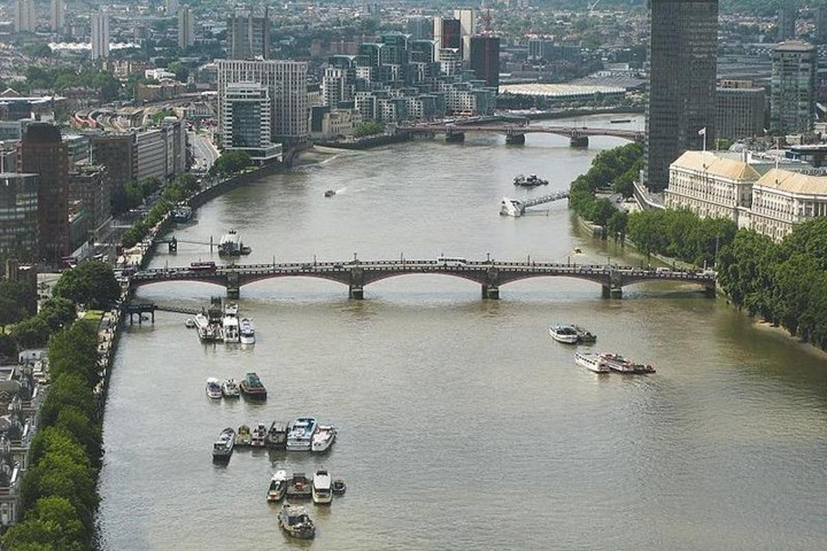 Вид з повітря на річку з човнами та мостом
