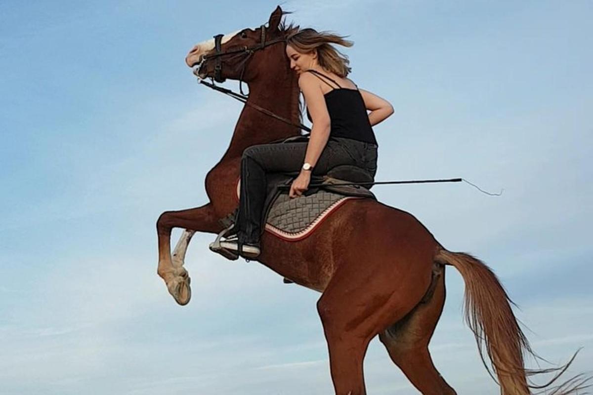 μια γυναίκα που καβαλάει στην πλάτη ενός αλόγου