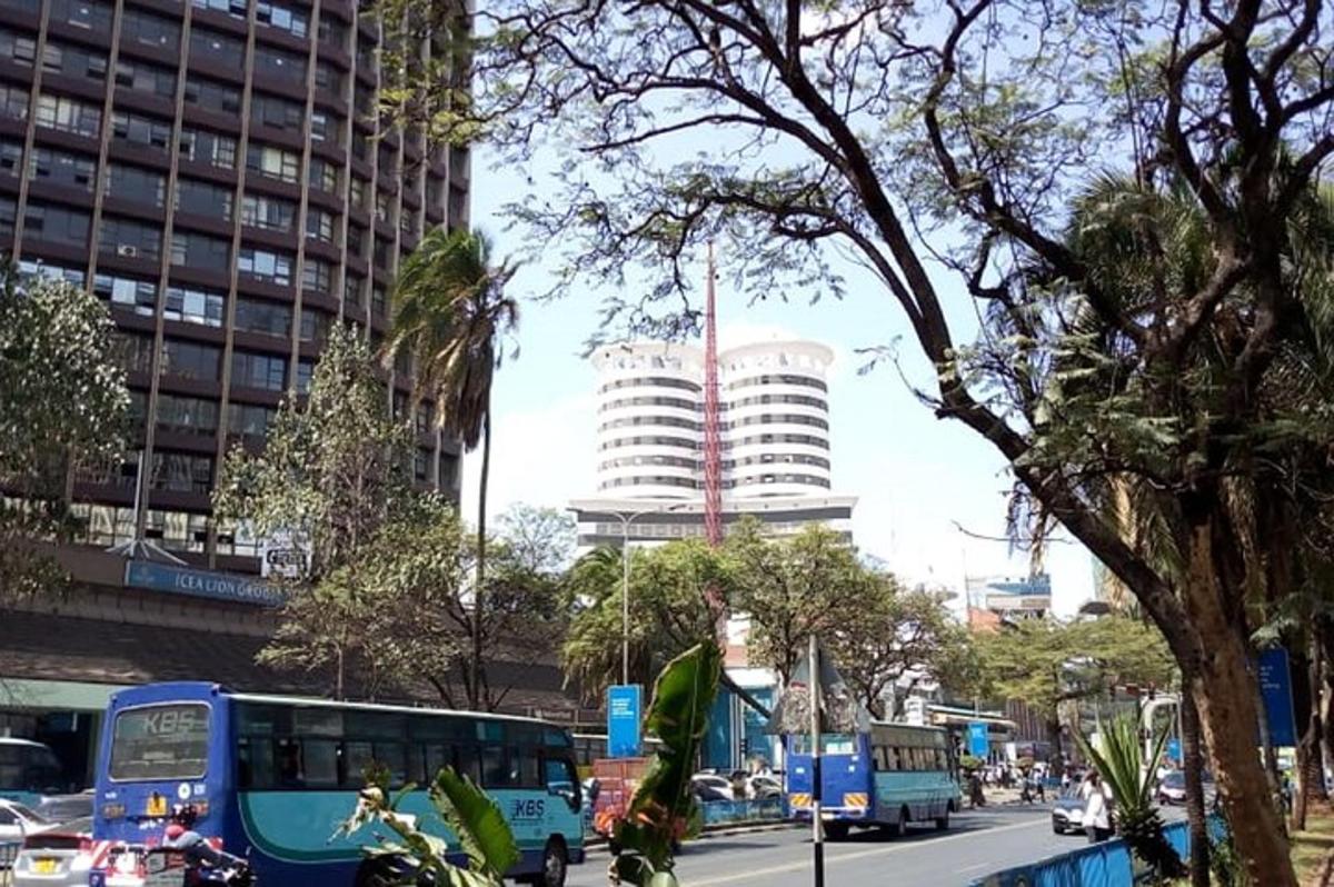 un carrer de la ciutat amb autobusos, cotxes i edificis