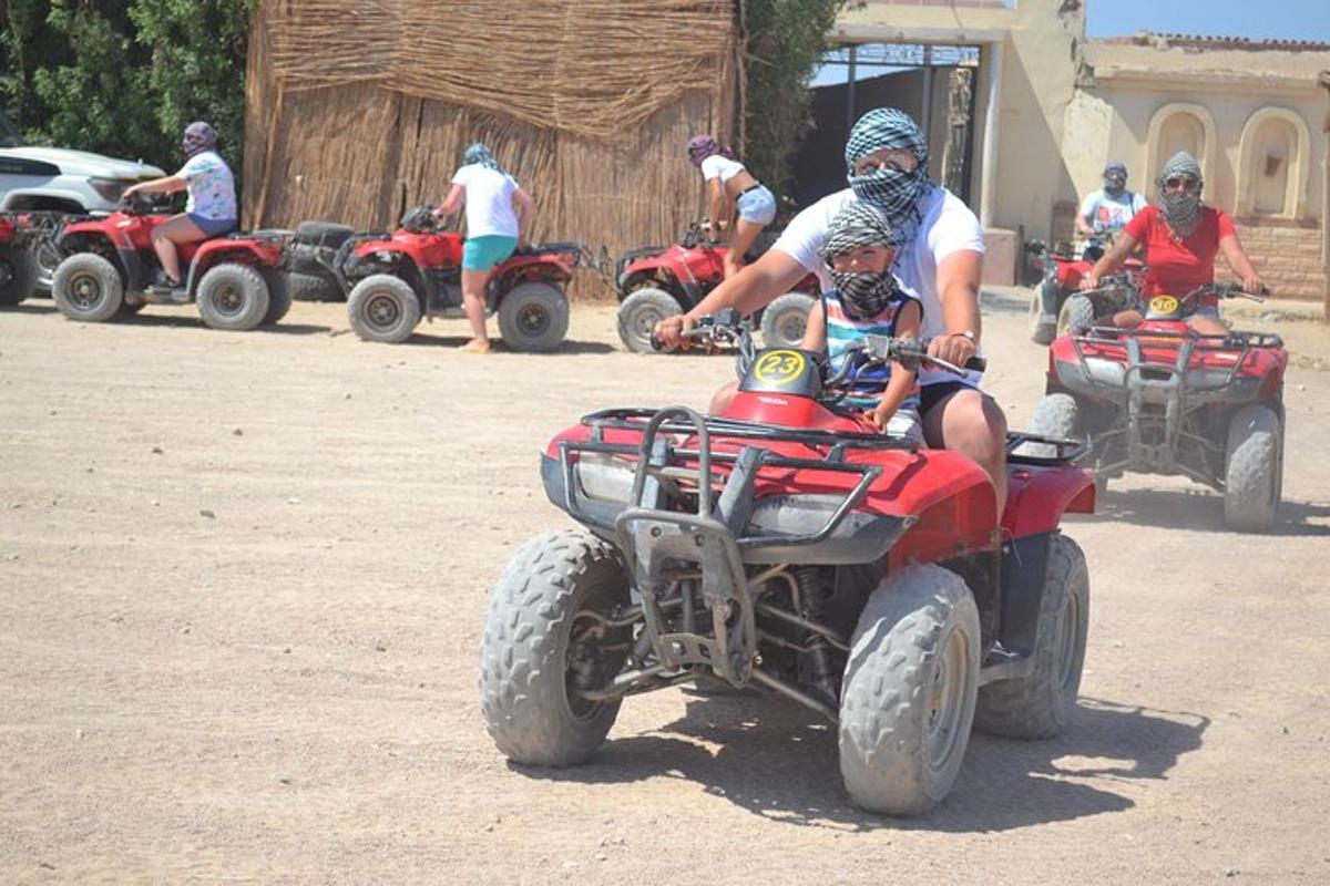 Un grupo de personas conduciendo vehículos todo terreno por un camino de tierra.