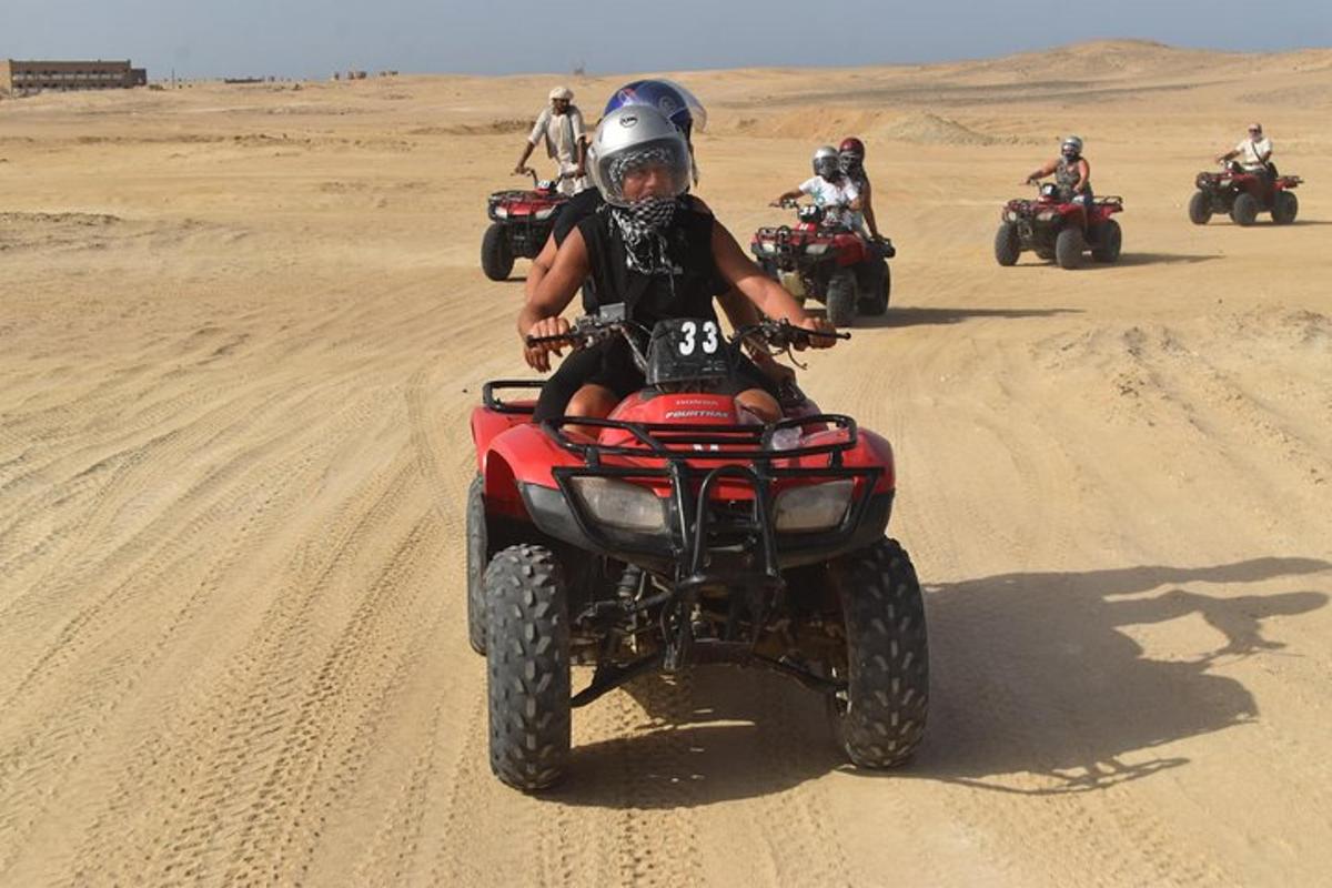 sekumpulan orang menunggang atv di padang pasir
