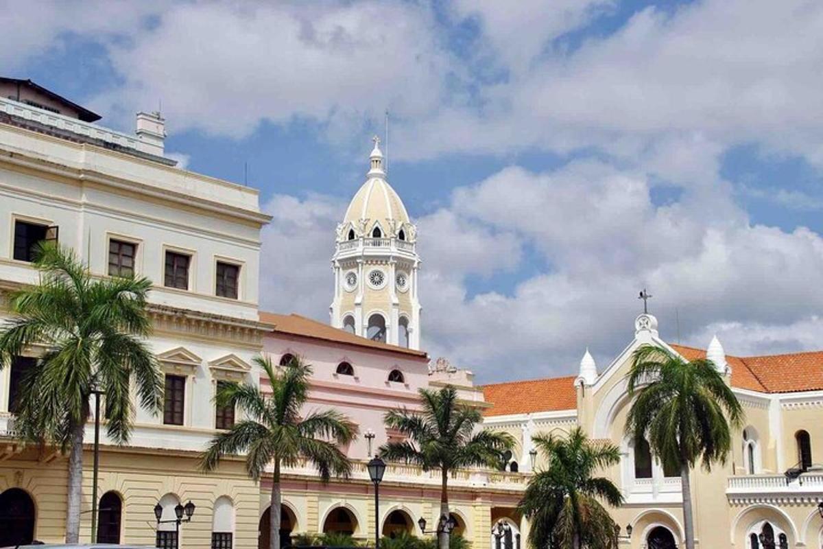a building with a clock tower and palm trees