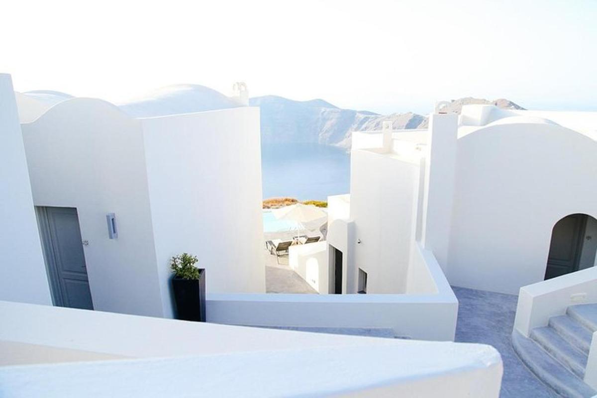 a view of the ocean from a balcony of white buildings